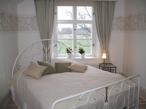 1 cama blanca en un dormitorio con ventana en Nygårds Herrgård Bed & Breakfast, en Mönsterås