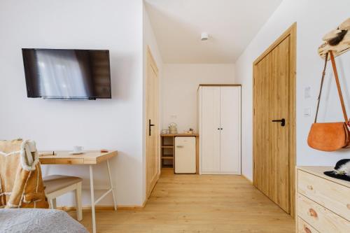 a bedroom with a desk and a door to a kitchen at Panocek i Babka in Białka Tatrzanska