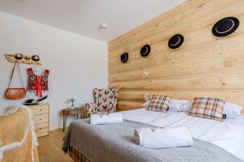 a bedroom with a bed with a wooden wall at Panocek i Babka in Białka Tatrzanska