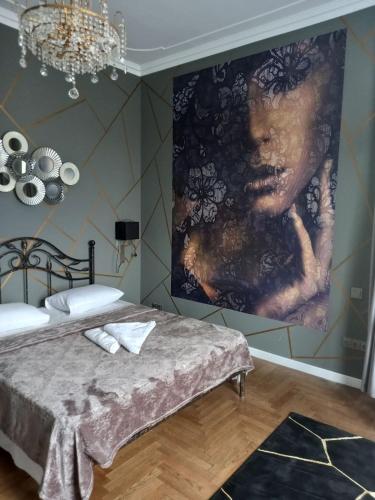 a bedroom with a large painting on the wall at Santorini in Chişinău