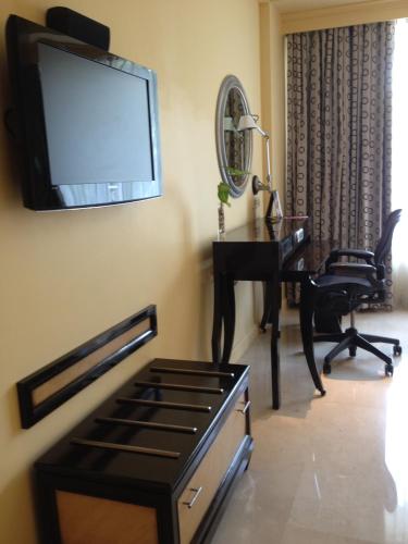 a living room with a desk and a television on the wall at Blue Diamond Pune IHCL SeleQtions in Pune