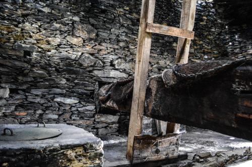 a wooden cross sitting next to a stone wall at Casa do Amieiro, Cantinho do Céu in Casal do Rei