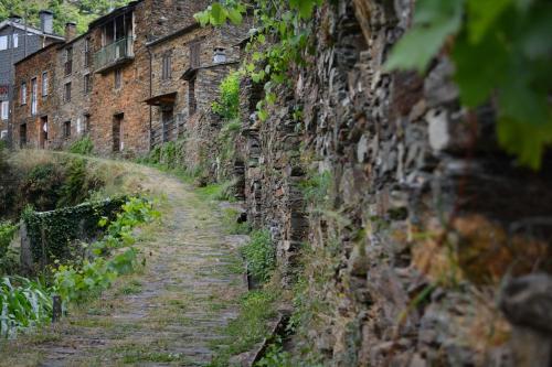an old stone wall with a dirt road at Casa do Amieiro, Cantinho do Céu in Casal do Rei