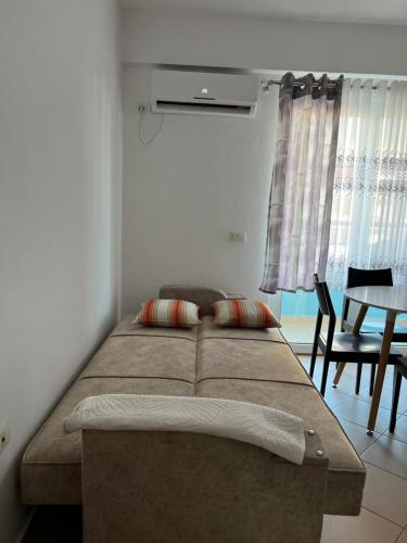 Bett in einem Zimmer mit Tisch und Stühlen in der Unterkunft LiXa Home in Shëngjin