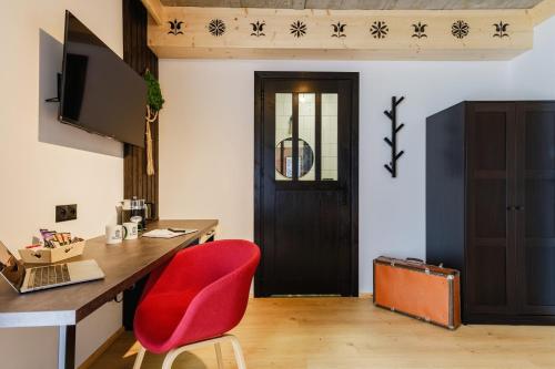 an office with a red chair and a desk and a door at Panocek i Babka in Białka Tatrzanska