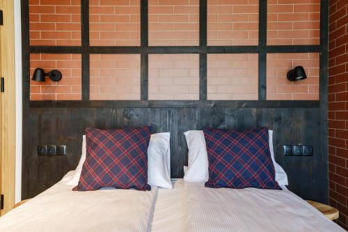 a bedroom with a bed with two red pillows at Panocek i Babka in Białka Tatrzanska