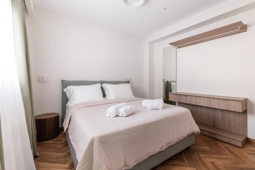 a bedroom with a bed with two towels on it at Helia All Seasons Apartments in Astris