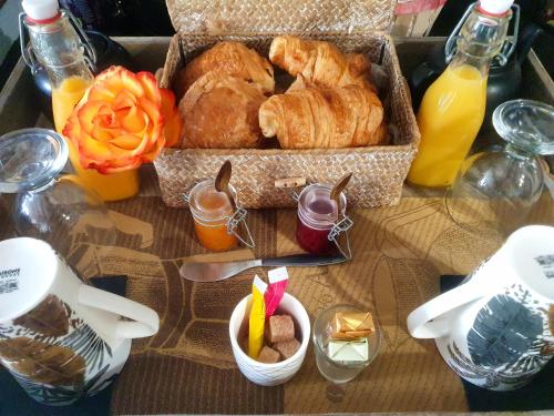 une table sur laquelle est posée une boîte de pâtisseries et d'autres aliments dans l'établissement LOVE Suites & SPA "Le Chai" avec lit rond, à Médis
