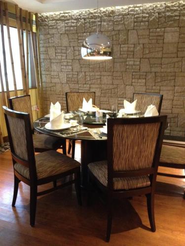 a dining room with a table and chairs and a stone wall at Blue Diamond Pune IHCL SeleQtions in Pune