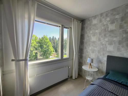 ein Schlafzimmer mit einem Bett und einem großen Fenster in der Unterkunft Nika Apartments in Imatra