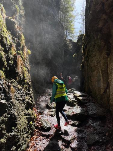 a person walking through a cave in a canyon at Villa Montana Borsec - Vedere Munte in Borsec