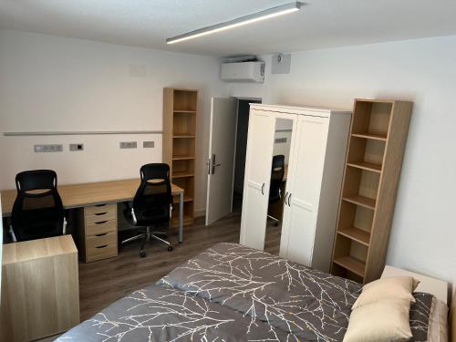 1 dormitorio con 1 cama, escritorio y 2 sillas en Habitacion DOBLE con baño compartido en Pozuelo dentro de casa tipo Boutique, en Pozuelo de Alarcón