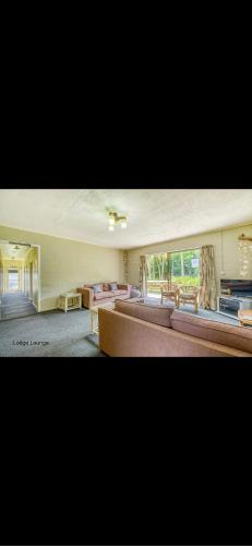 uma grande sala de estar com sofás e uma grande janela em Tekao Lodge em Te Kao
