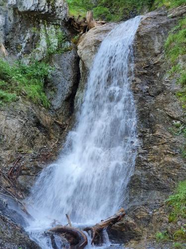 a waterfall on the side of a rocky mountain at Bichlhof in Kaisers