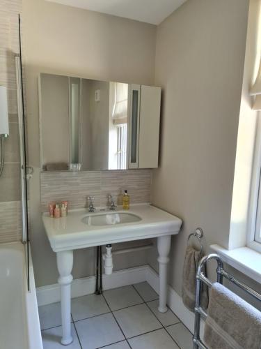 a bathroom with a sink and a mirror at Rainworth Lodge in Nottingham