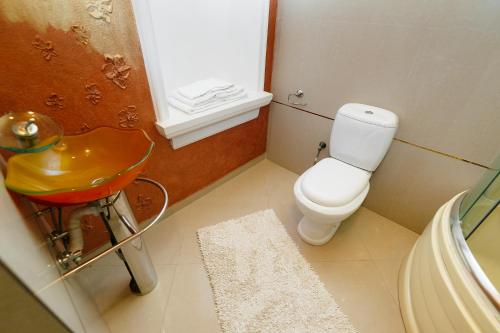 a bathroom with a white toilet and a sink at Santorini in Chişinău