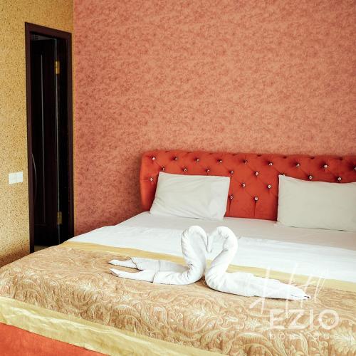 a bed with two white towels on it at Santorini in Chişinău