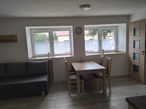 a living room with a table and a couch and windows at Ubytování na statku Račice in Račice
