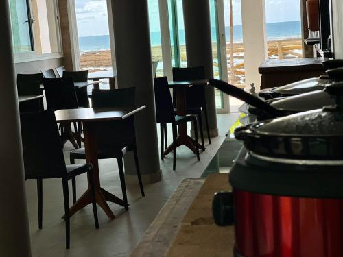 a restaurant with tables and chairs and the ocean at Pousada Pénareia in Morro de São Paulo