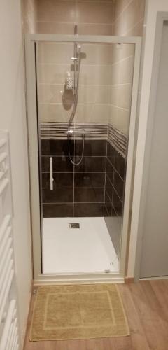 une douche avec une porte vitrée dans une salle de bain dans l'établissement KAPH, à Millau