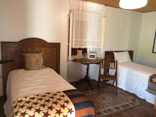 a bedroom with two beds and a table with a chair at Authentic Vila Nona by NYC Interior Architect in Susak
