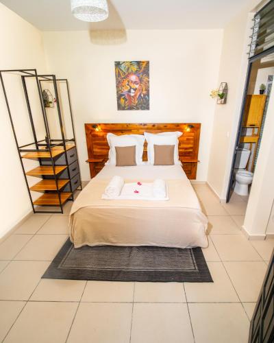 1 dormitorio con 1 cama grande en una habitación en Studio Jacuzzi et piscine au centre ville de Port-Louis, en Port-Louis