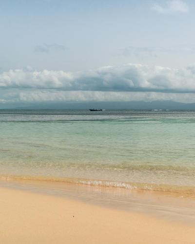 a boat in the ocean on a beach at Evasion en plein cœur de la ville Studio Jacuzzis Sauna et piscine au centre de Port-Louis in Port-Louis