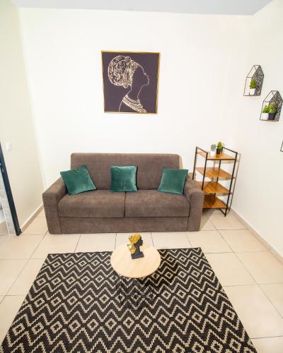 ein Wohnzimmer mit einem Sofa und einem Tisch in der Unterkunft T2 Jacuzzis et piscine au centre ville de Port-Louis in Port-Louis