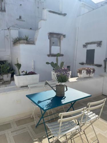 a blue table and chairs in a room with plants at BELLE HOME OSTUNI vasca vista mare in Ostuni