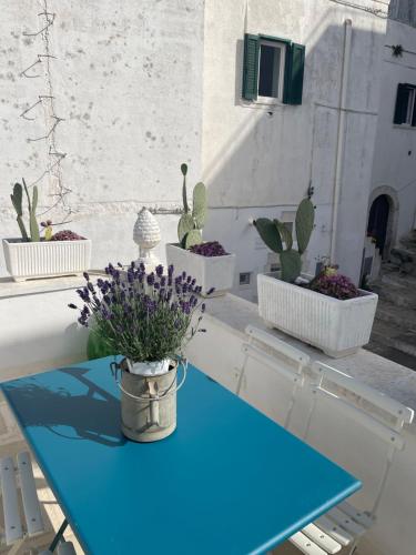 a blue table with three potted plants on it at BELLE HOME OSTUNI vasca vista mare in Ostuni