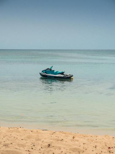 a boat sitting in the water on the beach at Evasion en plein cœur de la ville T2 Jacuzzis Sauna et piscine au centre de Port-Louis in Port-Louis