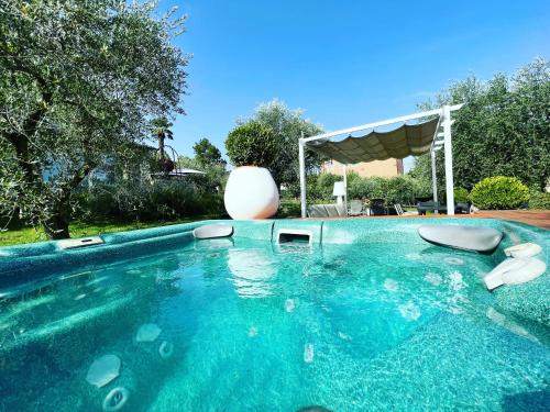 a swimming pool with chairs and a large vase at CorteViva Boutique B&B in Perugia