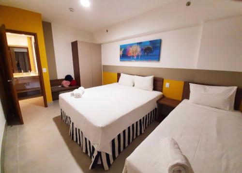 una camera d'albergo con due letti e una finestra di Olímpia Park resort 0908 a Olímpia