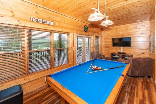a pool table in a room with wooden walls at Mountain Creek Lodge in Pigeon Forge