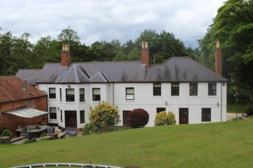 a large white house with a black roof at Rainworth Lodge in Nottingham