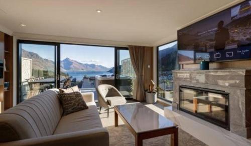 a living room with a couch and a large fireplace at The Carlin Boutique Hotel in Queenstown
