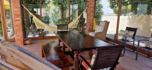 a wooden table and chairs in a room with windows at Afonso's House Alpendurada in Memorial