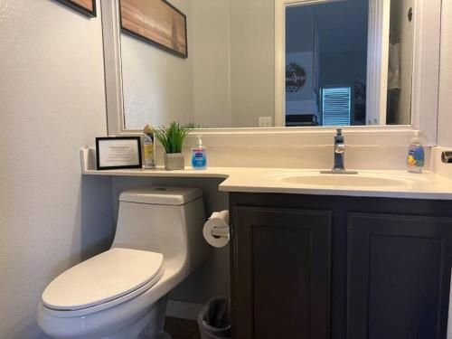 La salle de bains est pourvue de toilettes blanches et d'un lavabo. dans l'établissement Oasis pool house, optional pool heater, à Las Vegas