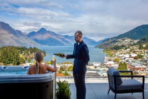 a man standing next to a woman in a hot tub at The Carlin Boutique Hotel in Queenstown