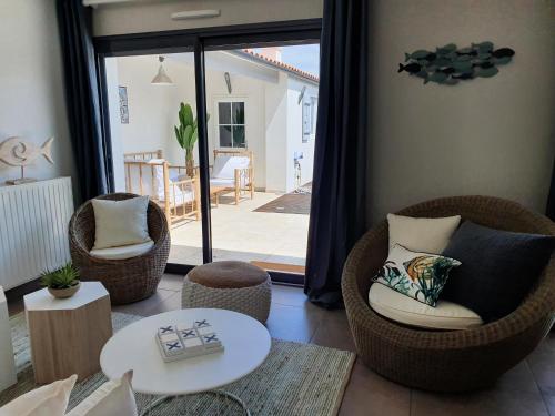 - un salon avec deux chaises et une table dans l'établissement Villa Bahia - ADRIAE Home, à LʼAiguillon-sur-Mer