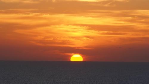a sunset over the ocean with the sun in the sky at Good Wave Surf House in Tamraght Oufella