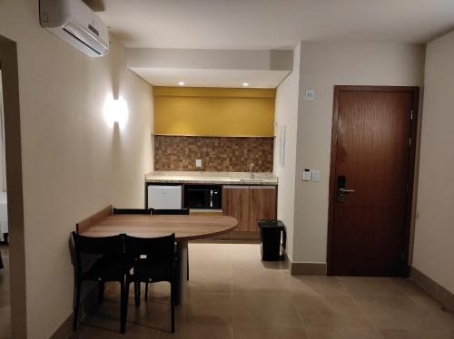 a kitchen with a large wooden table and chairs at Apartamento Solar das Águas Park Resort in Olímpia