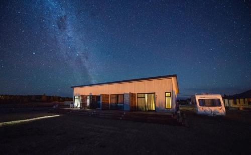 レイク・テカポにあるAlpine Studiosの夜間の駐車場内の小さな建物