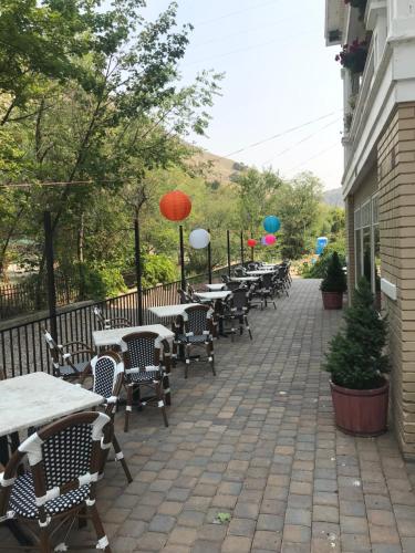 a row of tables and chairs with umbrellas on a patio at Riverside Hot Springs Inn & Spa - Adults Only in Lava Hot Springs
