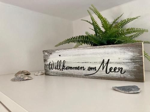 a sign on a shelf with a plant at Ferienhaus-Spatzenvilla in Lübeck