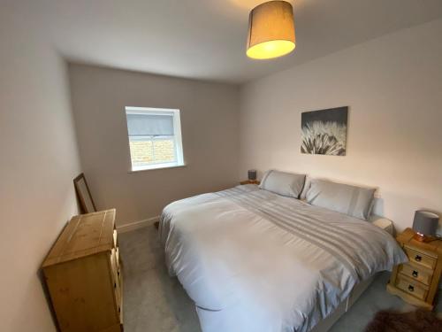 een slaapkamer met een wit bed en een raam bij Olde Post House, Rathmell - Settle in Settle