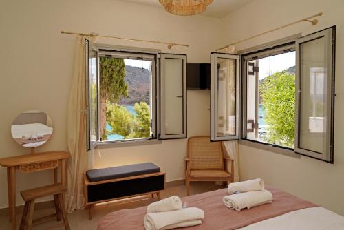 a bedroom with a bed and two windows with a view at Casa olive in Tolo