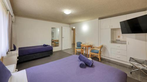 Un dormitorio con 2 camas y una mesa con comedor. en Hamilton Hume Motor Inn, en Yass