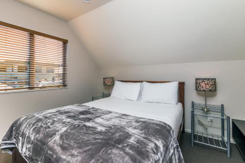 a bedroom with a large bed and a window at Twin Peaks Lakeside Inn in Taupo