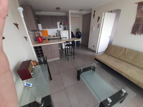 a living room with a couch and a kitchen at Departamentos Parque Costanera in Antofagasta